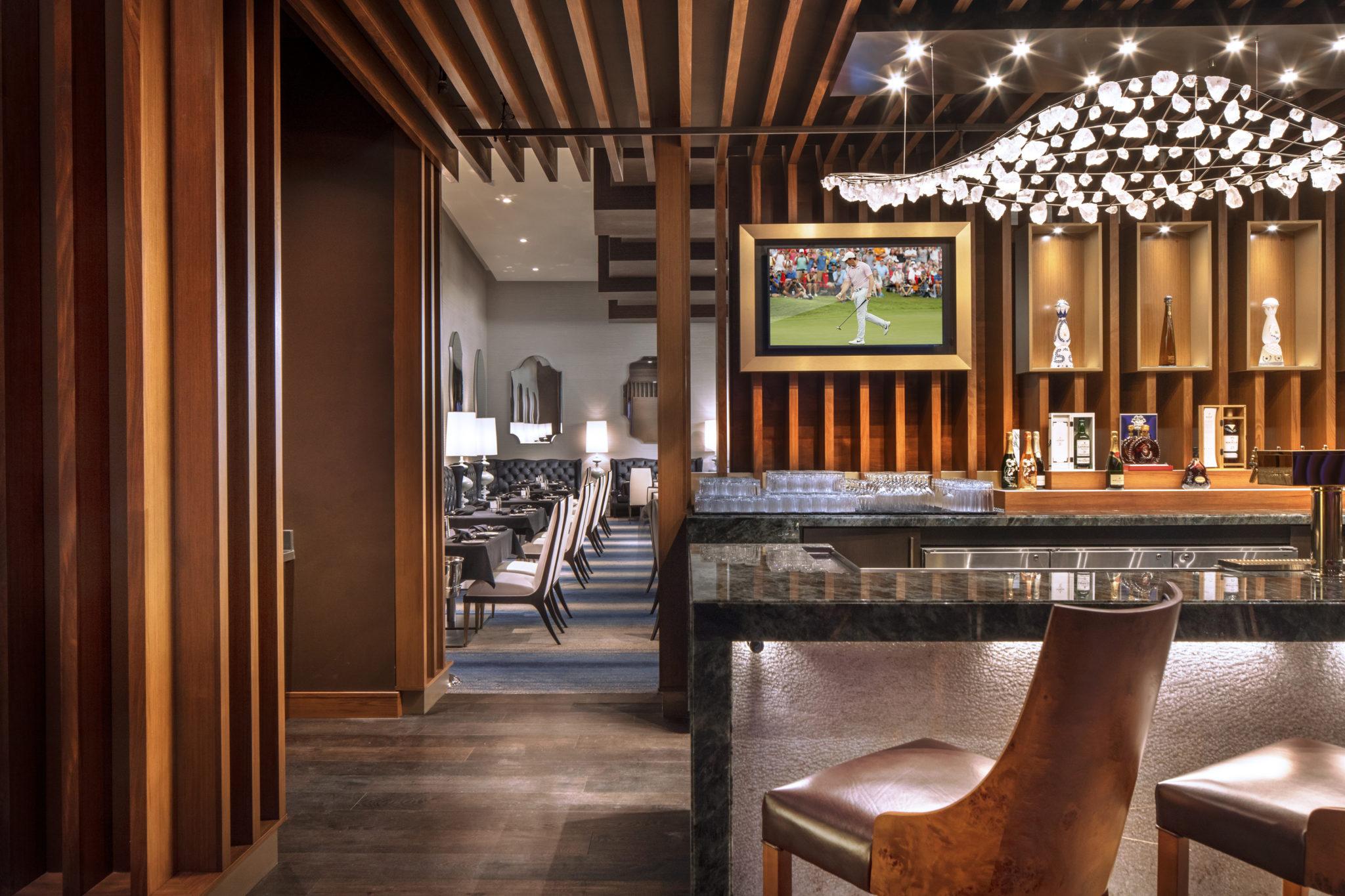 The bar and dining seating at Nineteen 86 with sculptural pendant lights and warm wood finishes
